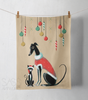 Tea towel with a greyhound or whippet and cat illustration wearing Christmas outfits.