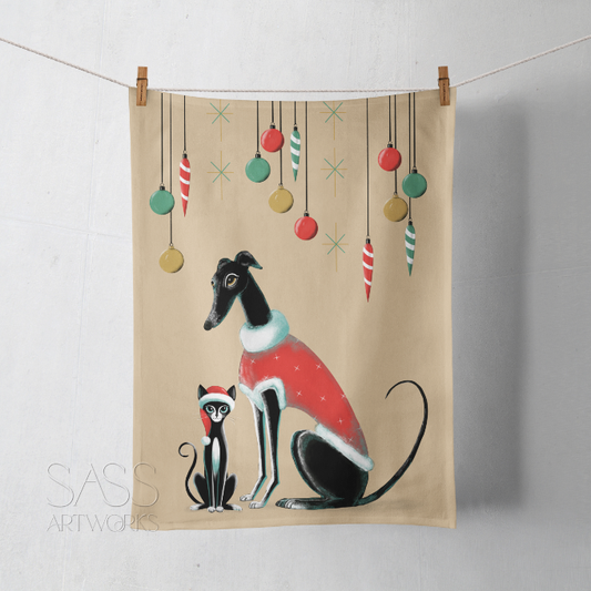 Tea towel with a greyhound or whippet and cat illustration wearing Christmas outfits.