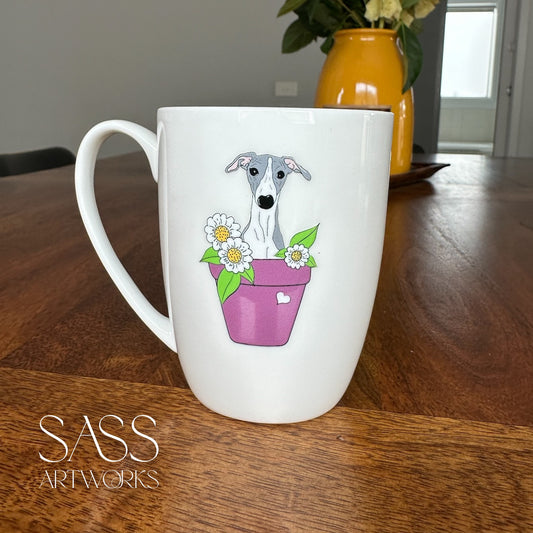 White mug with a dog illustration in a pot of flowers on a wooden table, featuring 'SASS Artworks' branding.