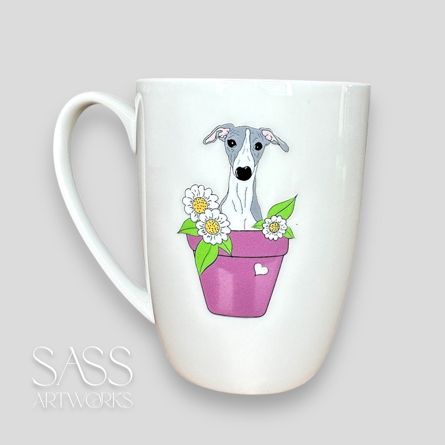 White mug with a dog and flower design on a light gray background, featuring 'SASS Artworks' branding.