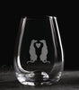 Clear glass with engraved design of two animals holding a heart on a dark background