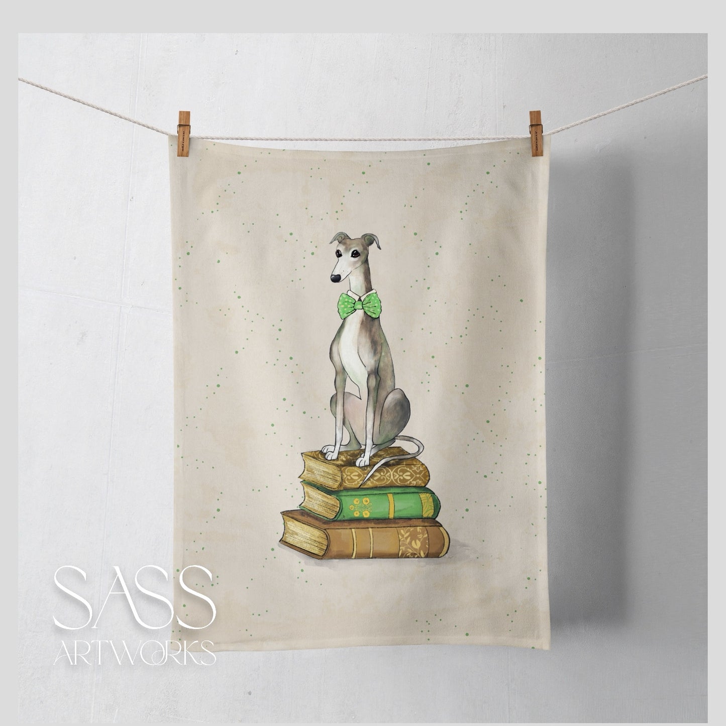 Tea towel with a whippet seated on a stack of books  on a white background
