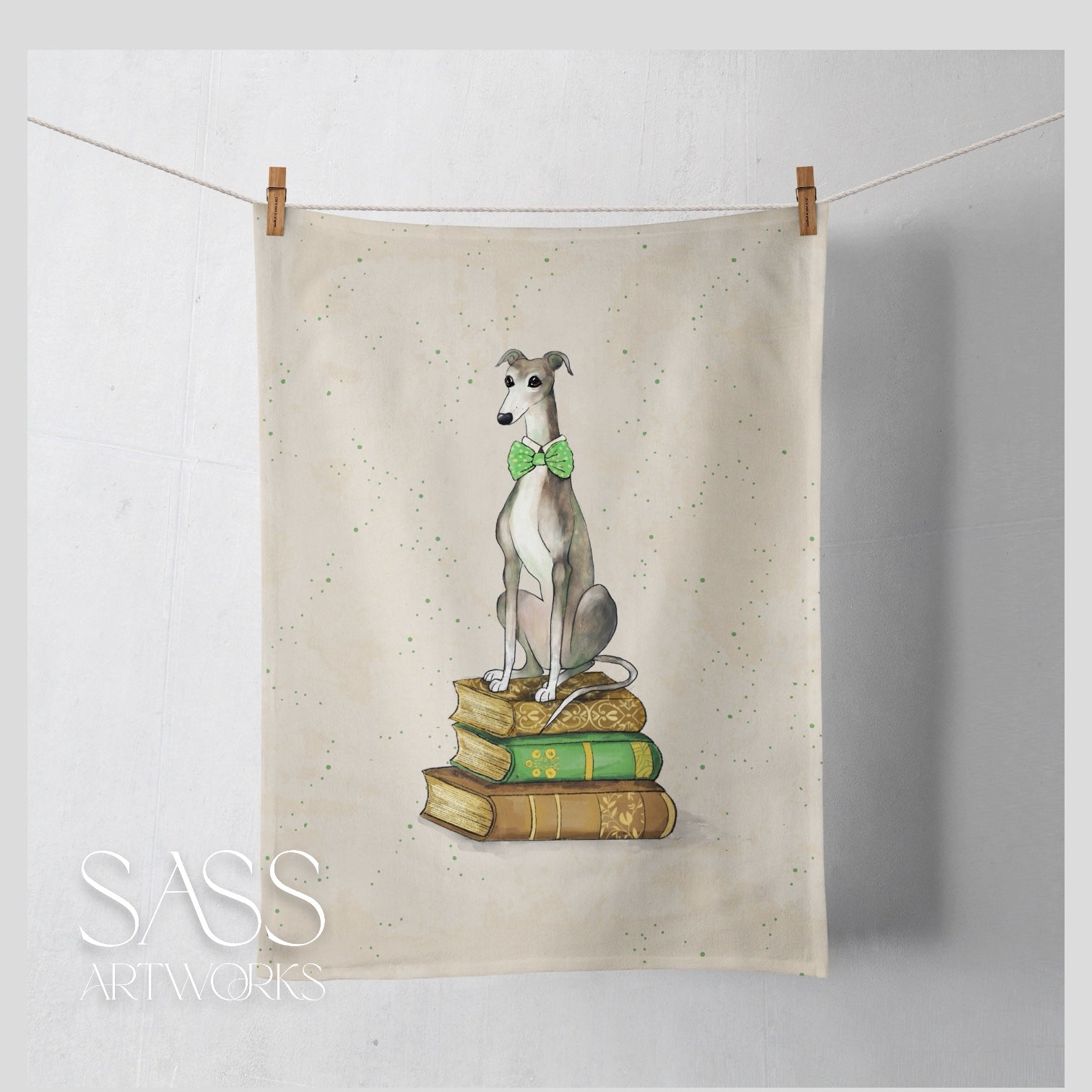 Tea towel with a whippet seated on a stack of books  on a white background