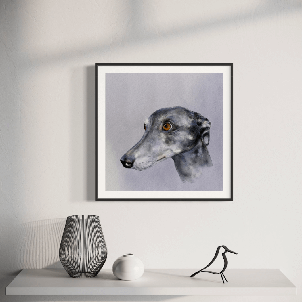 Framed artwork of a greyhound or whippet portrait on a wall above a white surface with decorative items.